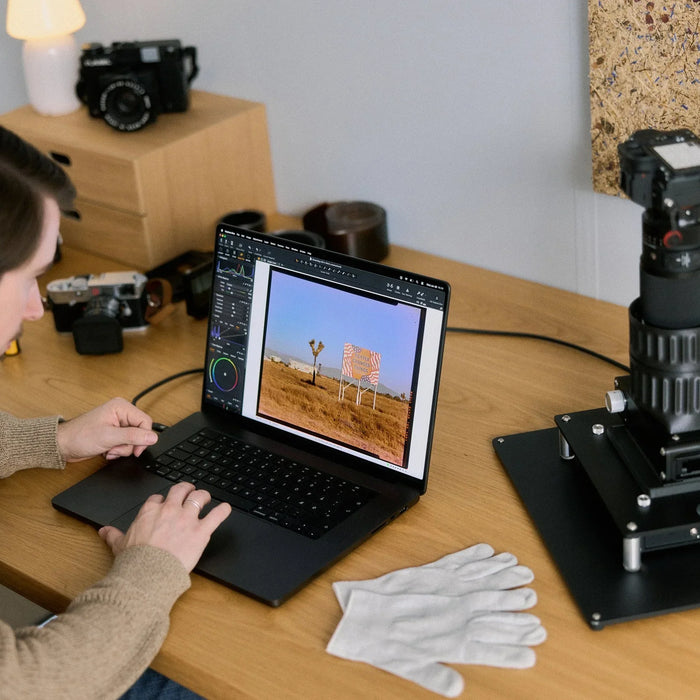 Reviewing a digitised film photograph on a laptop beside a Negative Supply camera-scanning setup