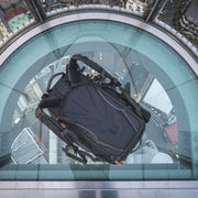 An image of the Shimoda Explore V2 25 Backpack Starter Kit in black, pictured on a platform above a cityscape.