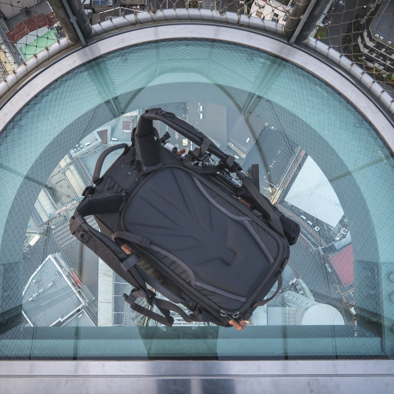 An image of the Shimoda Explore V2 25 Backpack Starter Kit in black, pictured on a platform above a cityscape.